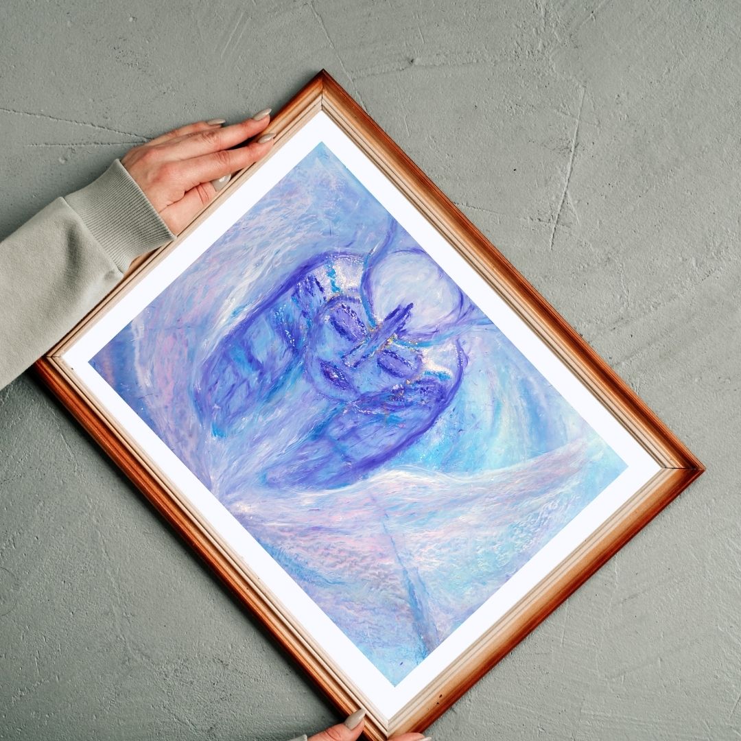 "Blessing of Hathor" art print framed in a wooden frame, displayed on a gray background. Hathor is depicted in light blue, purple, and white, with white wings emerging from her heart and walking toward a white sphere forming her headdress.