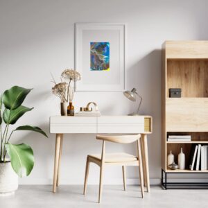 A framed Scorpio painting on a white wall above a Scandinavian-style desk, depicting a galloping horse against a vivid blue sky with a rainbow, set in a white frame with a large mount.