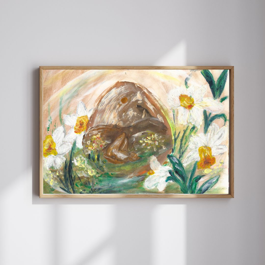 A framed painting of a curled-up figure inside a cave-like formation, surrounded by blooming white and yellow flowers. The artwork features earthy tones, soft green hues, and a subtle rainbow arch in the background.